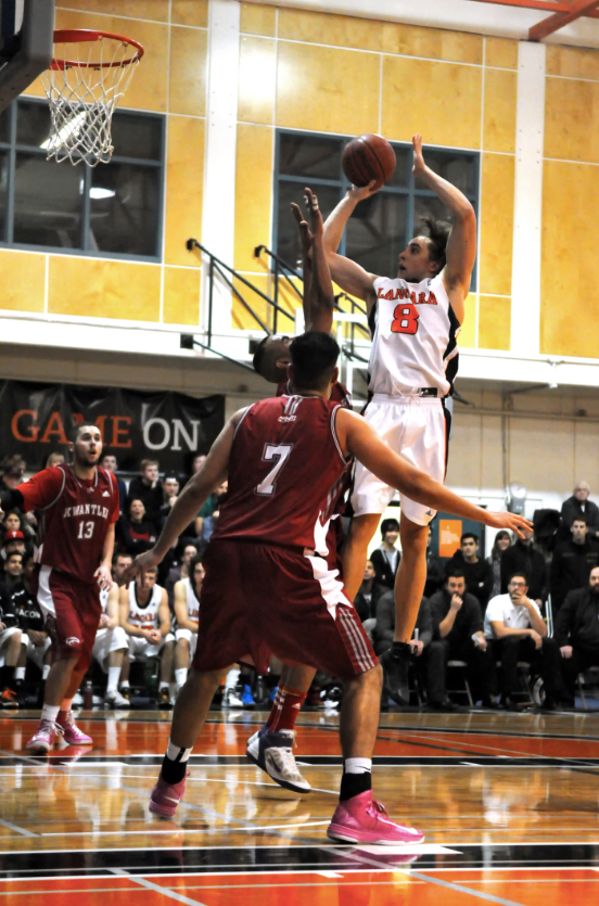  Falcons' Devin McMurtry elevates over Kwantlen's Ali Bosir for a tough floater Friday night. McMurtry finished with 14 points, along with eight rebounds and six assists